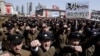 University students punch the air as they march through Kim Il Sung Square in downtown Pyongyang, North Korea, March 29, 2013. 