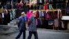 Two ethnic Uighur men walk in a clothing market in downtown Urumqi, Xinjiang province, Nov. 1, 2013. 