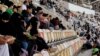 Saudi women watch the soccer match between Al-Ahli against Al-Batin at the King Abdullah Sports City in Jeddah, Saudi Arabia, Jan. 12, 2018.