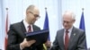 Thủ tướng lâm thời Ukraina Arsenyi Yatsenyuk (trái) và Chủ tịch Hội đồng châu Âu Herman Van Rompuy trao đổi tài liệu tại lễ ký hiệp ước ở Brussels, 21/3/2014.