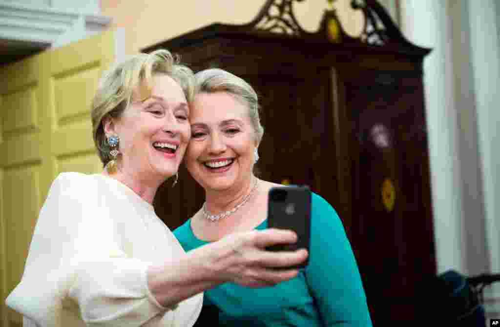 Nữ diễn vi&ecirc;n Meryl Streep sử dụng&nbsp; iPhone để chụp ảnh với b&agrave; Clinton sau buổi dạ tiệc tại Bộ Ngoại Giao ở Washington, 1-12-2012 .