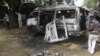 Men inspect a bus following an explosion on the street in Potiskum, Nigeria, Feb. 24, 2015 . 